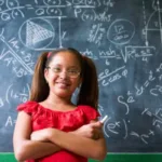 A child in front of a blackboard explaining what business expenses are tax deductible