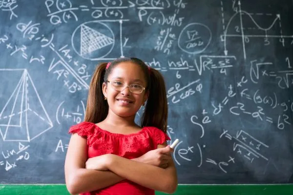 A child in front of a blackboard explaining what business expenses are tax deductible