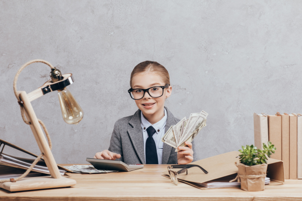 A kid dressed up as an accoutant, sat at a desk, about to explain why budgeting is so important.